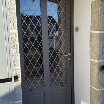 porte d'entrée aluminium noire avec vitres et grillage