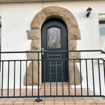 Porte d'entrée cintrée avec garde-corps